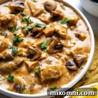 A bowl of Instant Pot Chicken Stroganoff with a side of mashed potatoes, ready to be enjoyed.