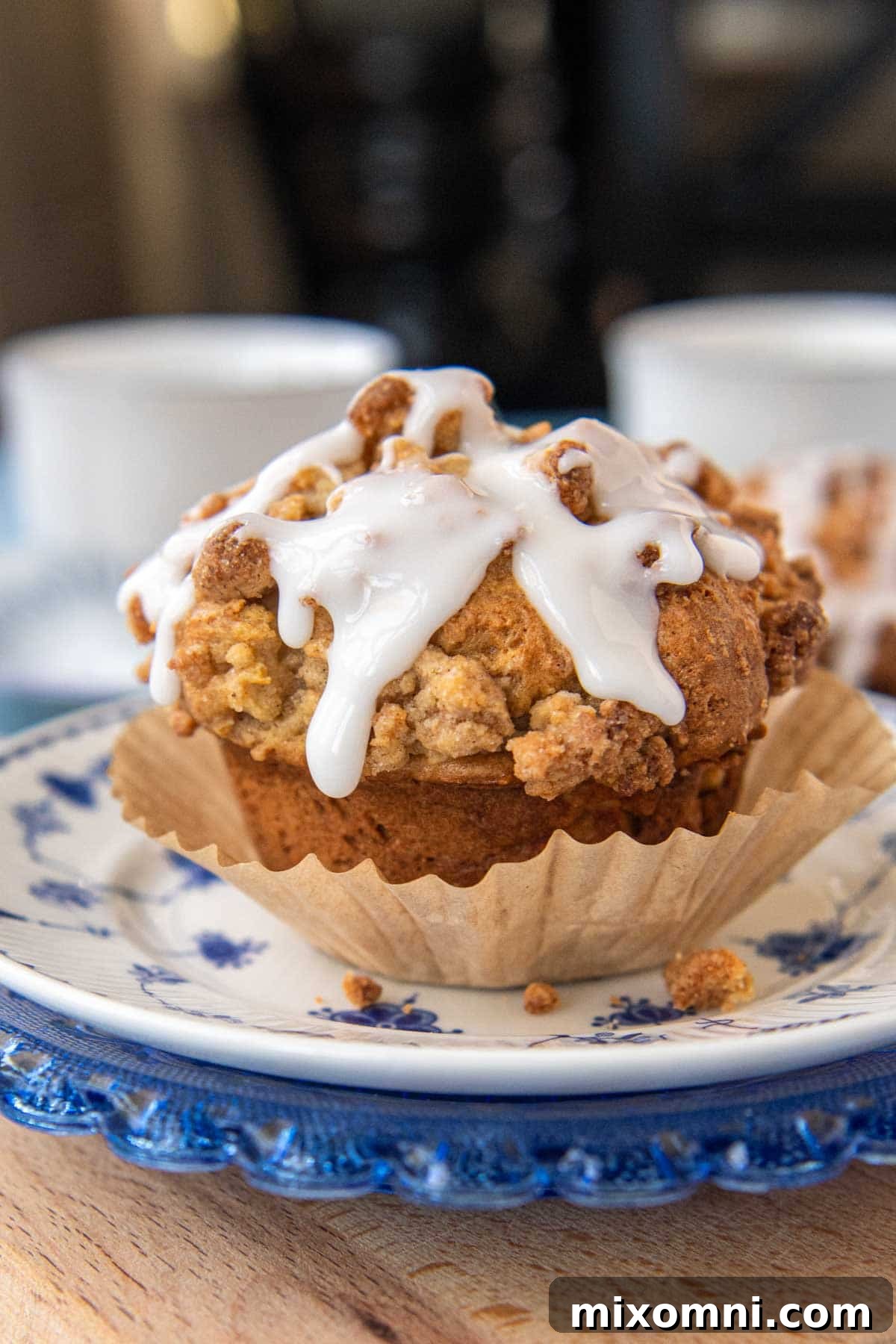 A perfectly baked gluten-free apple muffin, partially unwrapped from its paper liner, ready to be enjoyed.