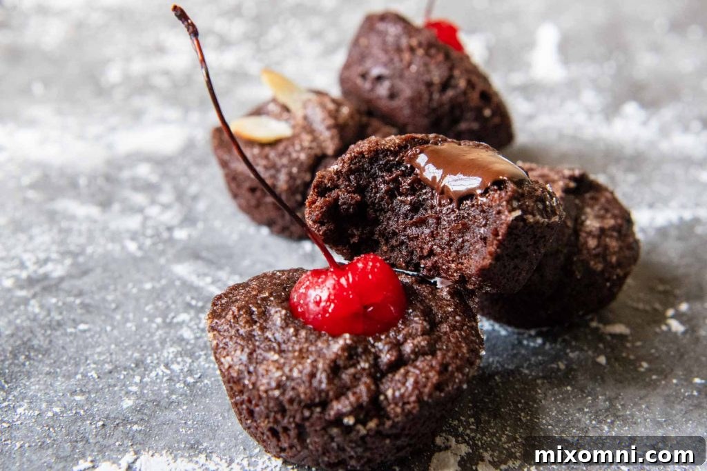 a financier with a bite taken out and melted chocolate dripping down