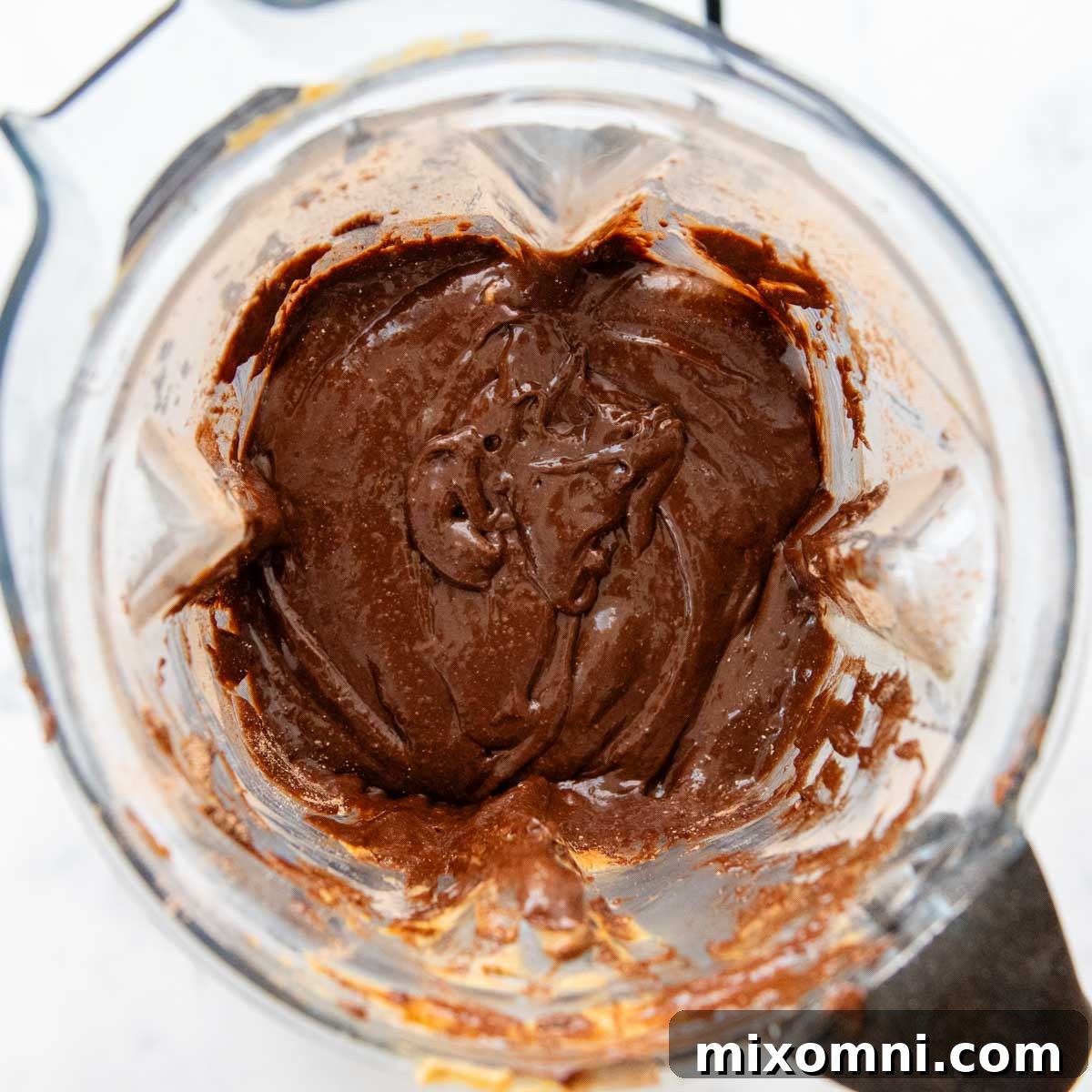 The thick, dark brown oat flour brownie batter after all ingredients have been blended, showing its smooth consistency.