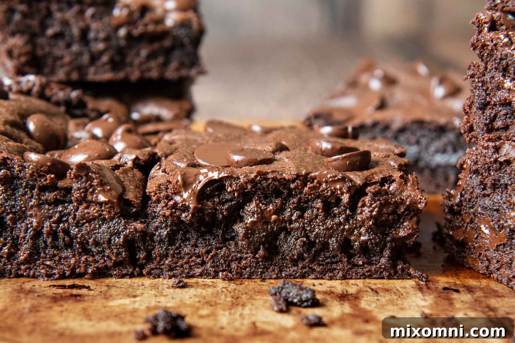 A perfectly cut oat flour brownie, shown up close and straight on, revealing its dense, fudgy interior and melted chocolate chips.