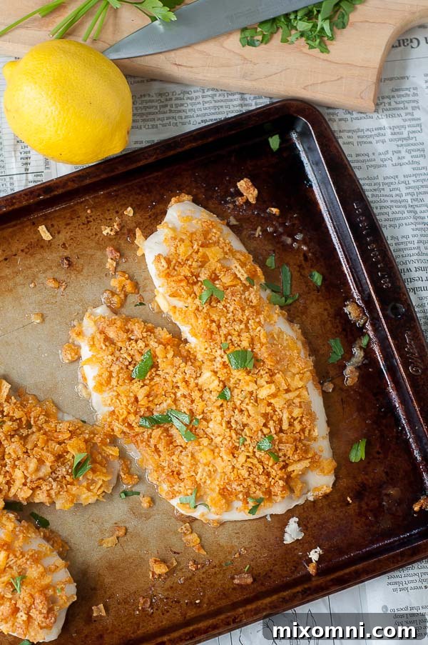 Crispy oven-fried fish on a baking sheet, golden brown and perfectly cooked, ready to be served with delicious sides.