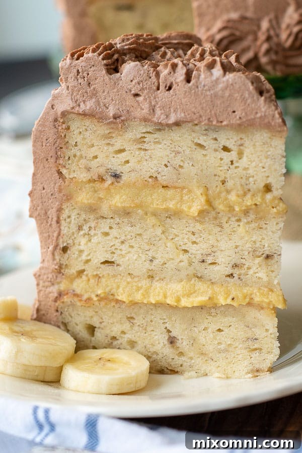 a piece of fluffy banana cake with banana filling standing straight up on a plate