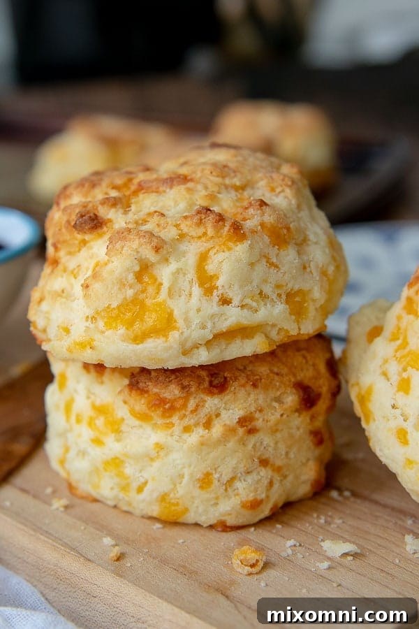 a stack of 2 gluten free cheese scones on a wood cutting board