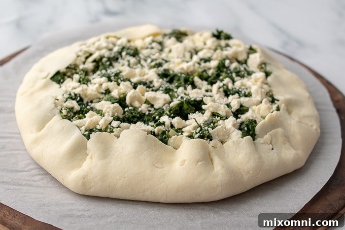 A detailed shot illustrating how the pastry crust is elegantly folded over the filling, creating a rustic galette-style border.
