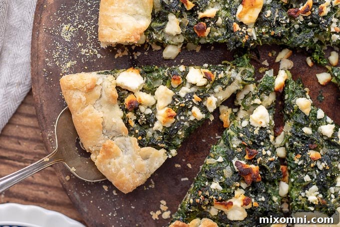 A slice of the Savory Vegetable Tart being carefully lifted from the baking dish with a spatula, showcasing its beautiful layers.