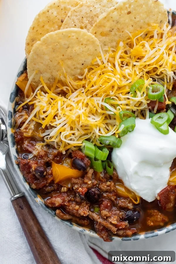 A close-up overhead shot of a steaming bowl of healthy turkey chili, garnished with fresh cilantro, ready to be enjoyed.
