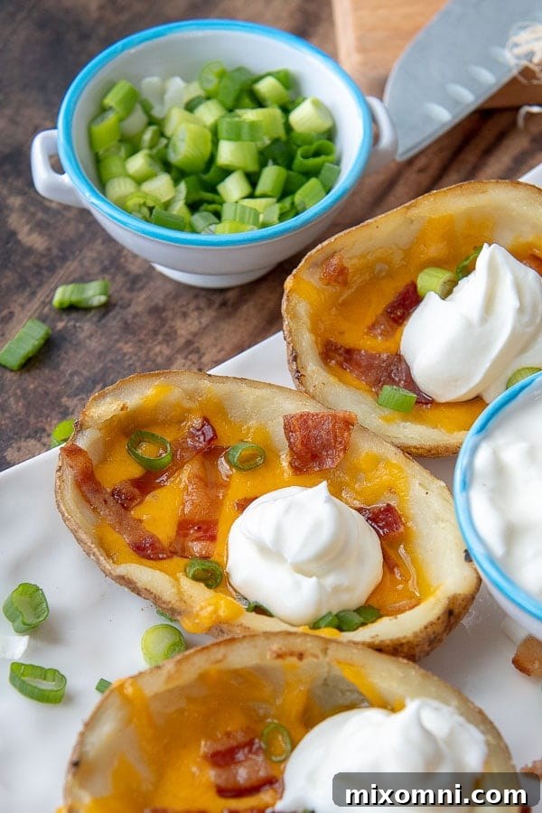 A close-up shot of a perfectly loaded potato skin, generously topped with a dollop of sour cream, ready to be enjoyed.