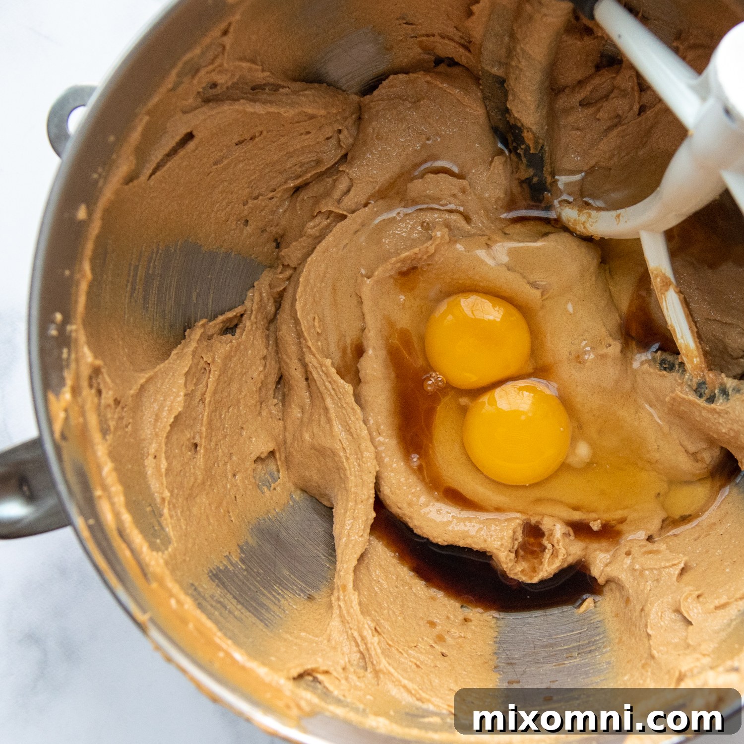The butter and sugar mixture, light and creamy, with eggs and vanilla extract freshly added, ready for the next ingredients.