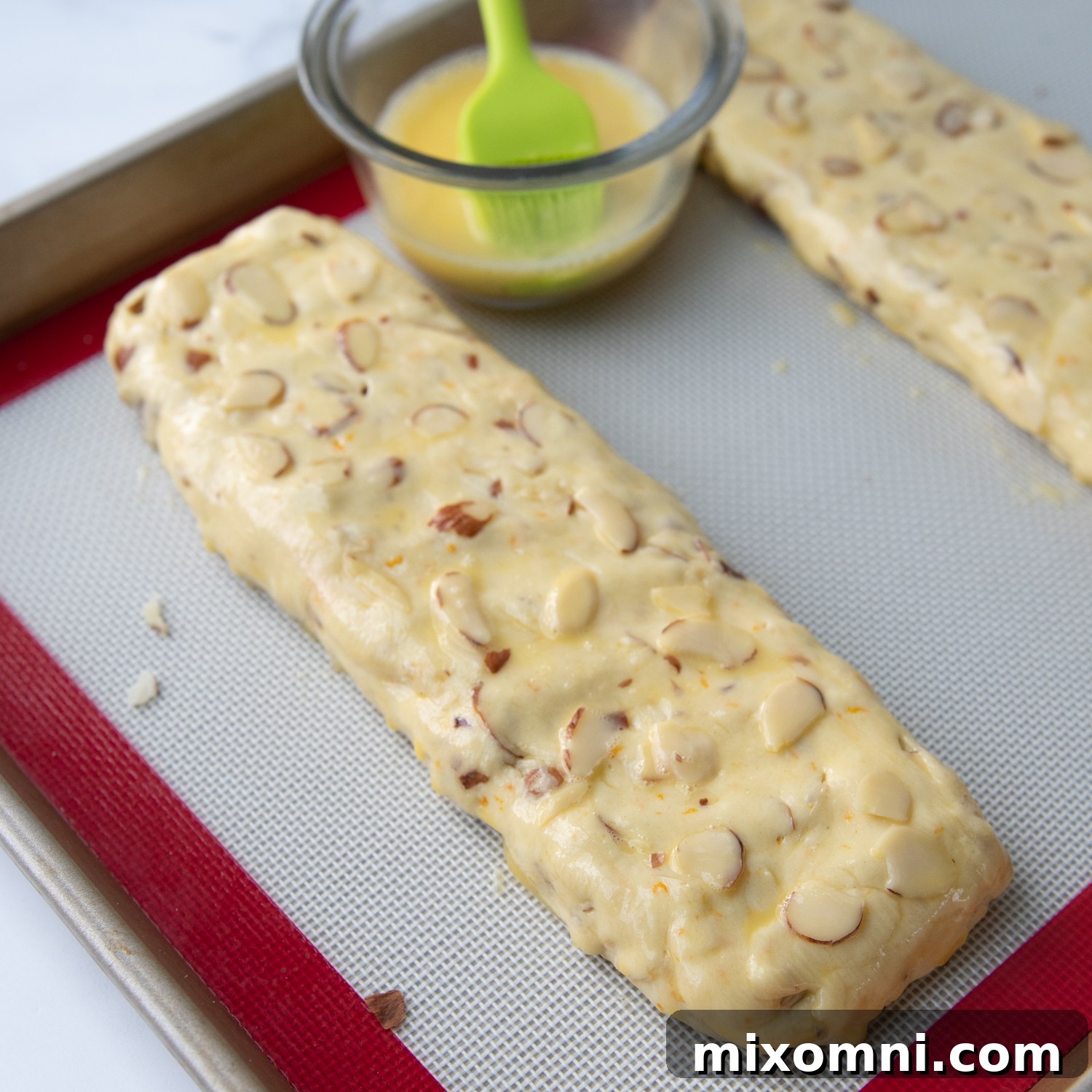 brushing an egg wash on the unbaked biscotti log.