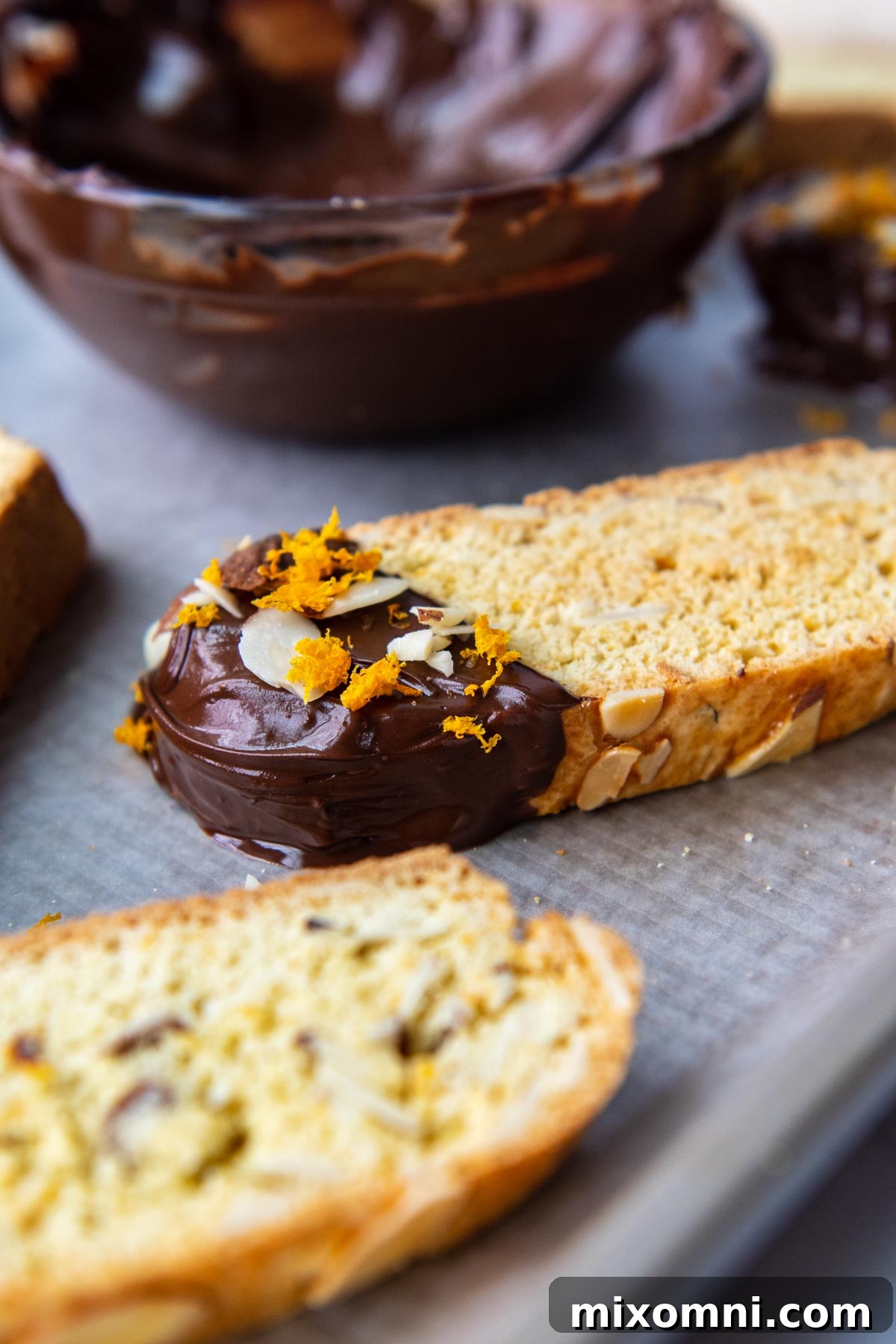 close up of chocolate tip of biscotti on a baking sheet