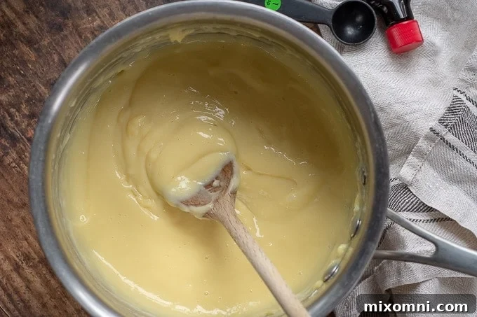 A close-up shot of creamy vanilla custard in a saucepan.