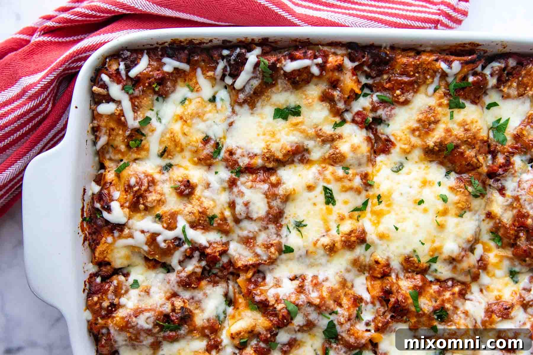 A close-up, appetizing overhead shot revealing the perfectly structured and deliciously cheesy corner of a freshly baked lasagna dish, beckoning to be served and enjoyed.