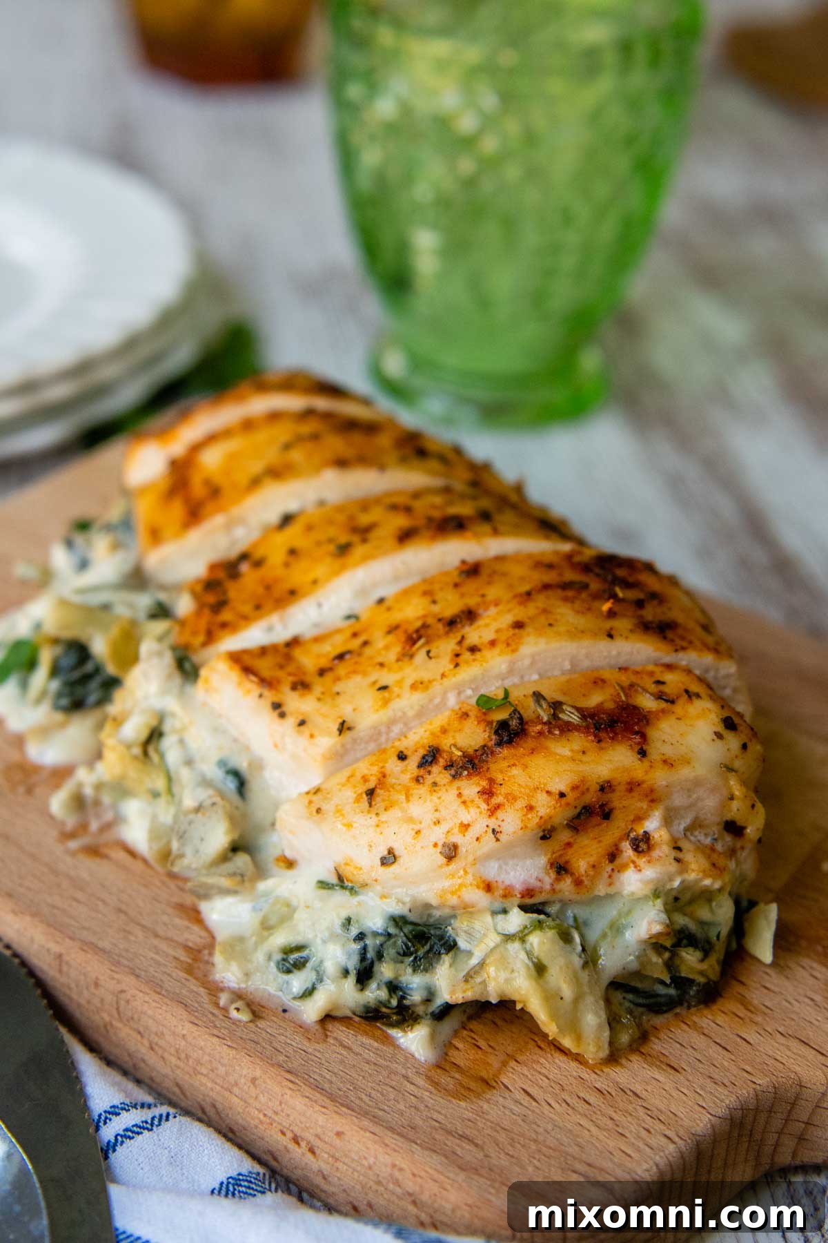 Overhead view of perfectly baked and sliced spinach artichoke stuffed chicken, showcasing the vibrant and creamy filling in each piece.