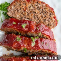 a slice of face up meatloaf on a white plate