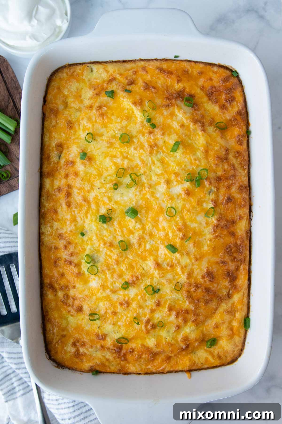 A beautifully baked egg casserole adorned with fresh green onions, showcasing its appetizing golden crust.