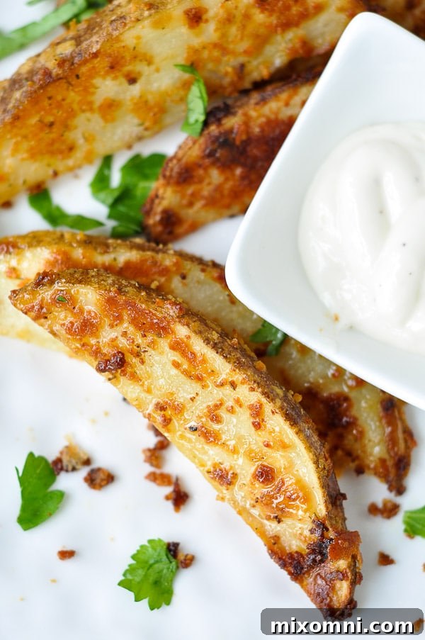 ranch potatoes on a white plate with a small bowl of ranch dressing next to it