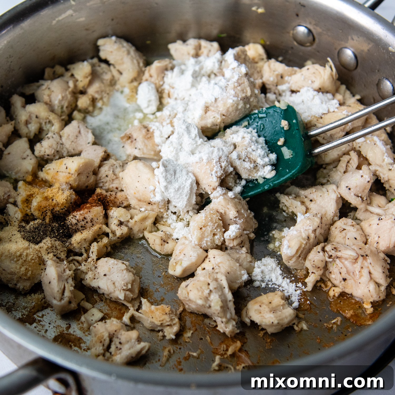the chicken coated with flour in a saute pan.