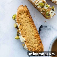 A face-up slice of gluten-free almond flour biscotti, perfectly baked, with a cup of coffee in the corner of the frame.