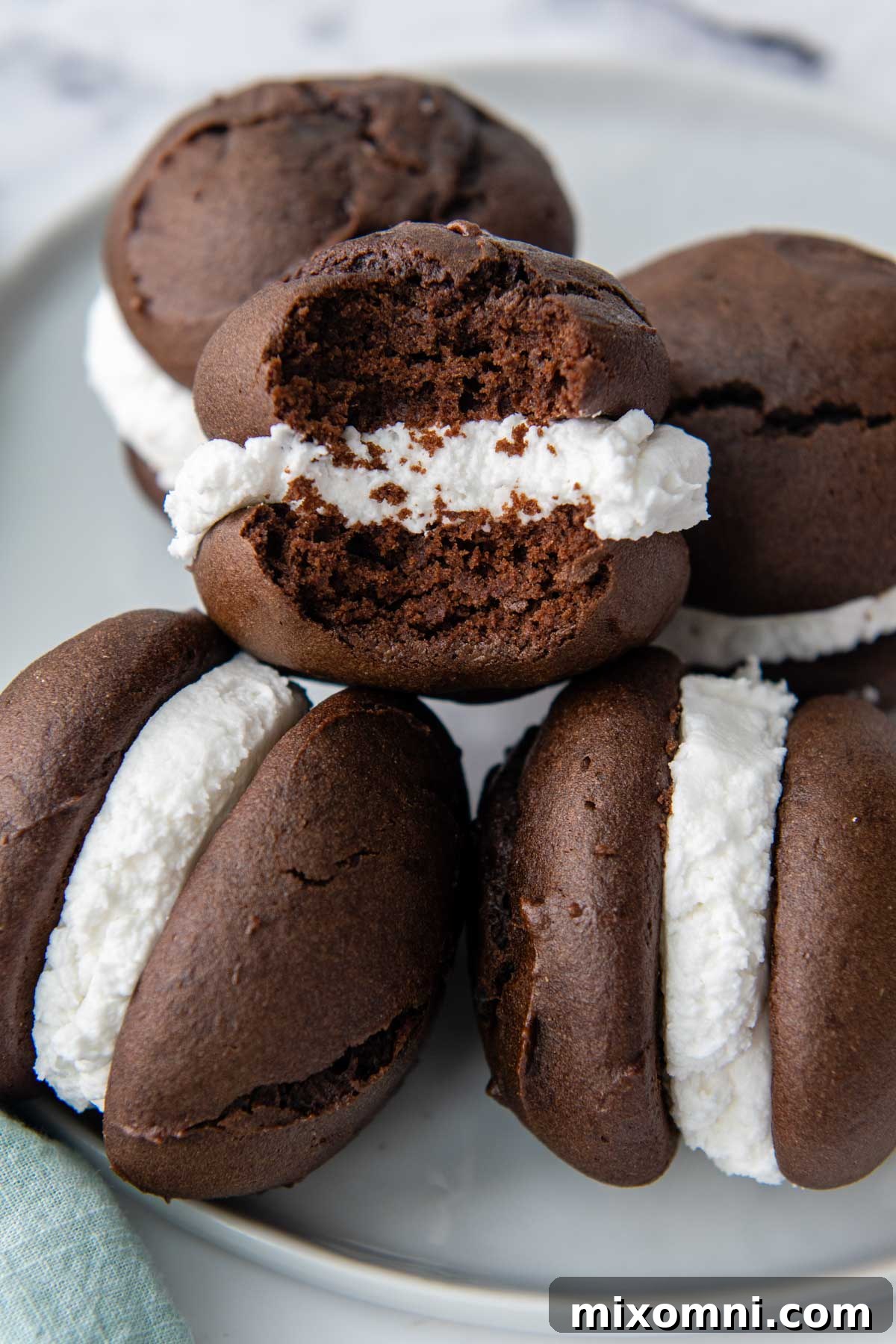 a stack of whoopie pies on a plate with one missing a bite