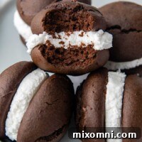 a stack of whoopie pies on a plate with one missing a bite