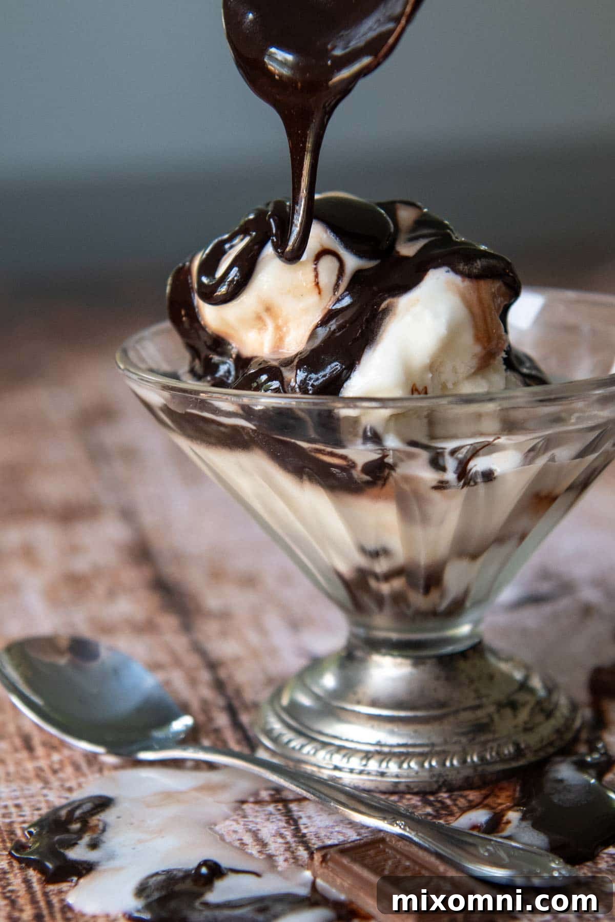 chocolate syrup on melting ice cream in a footed dish