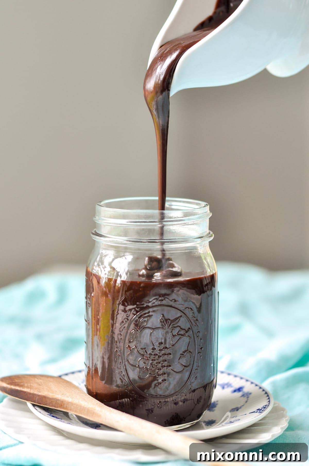 hot fudge sauce being poured into a glass jar
