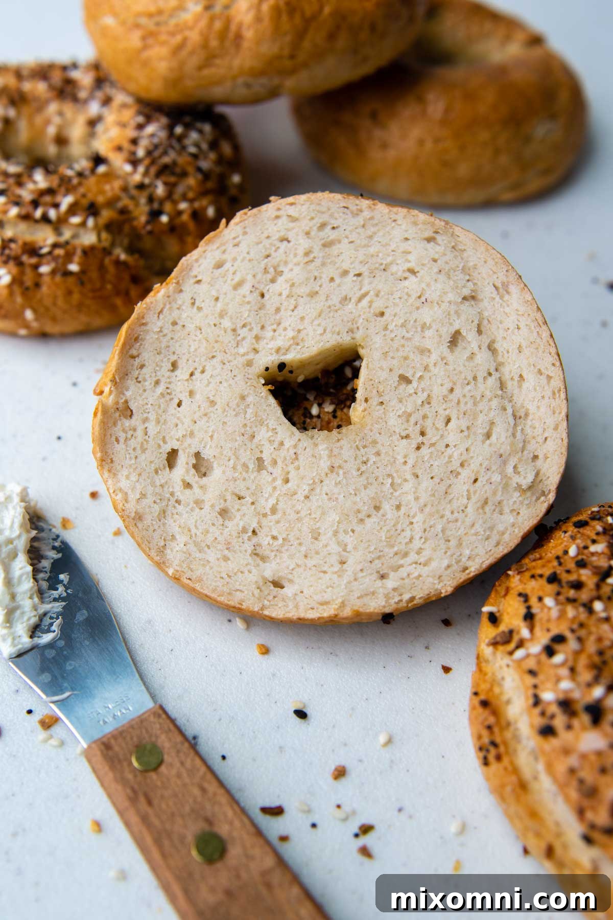a sliced bagel with other bagels around.