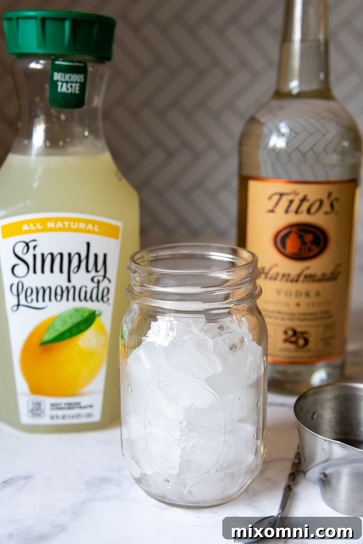 Ingredients for making a single serving of vodka lemonade: vodka, lemonade, and ice.