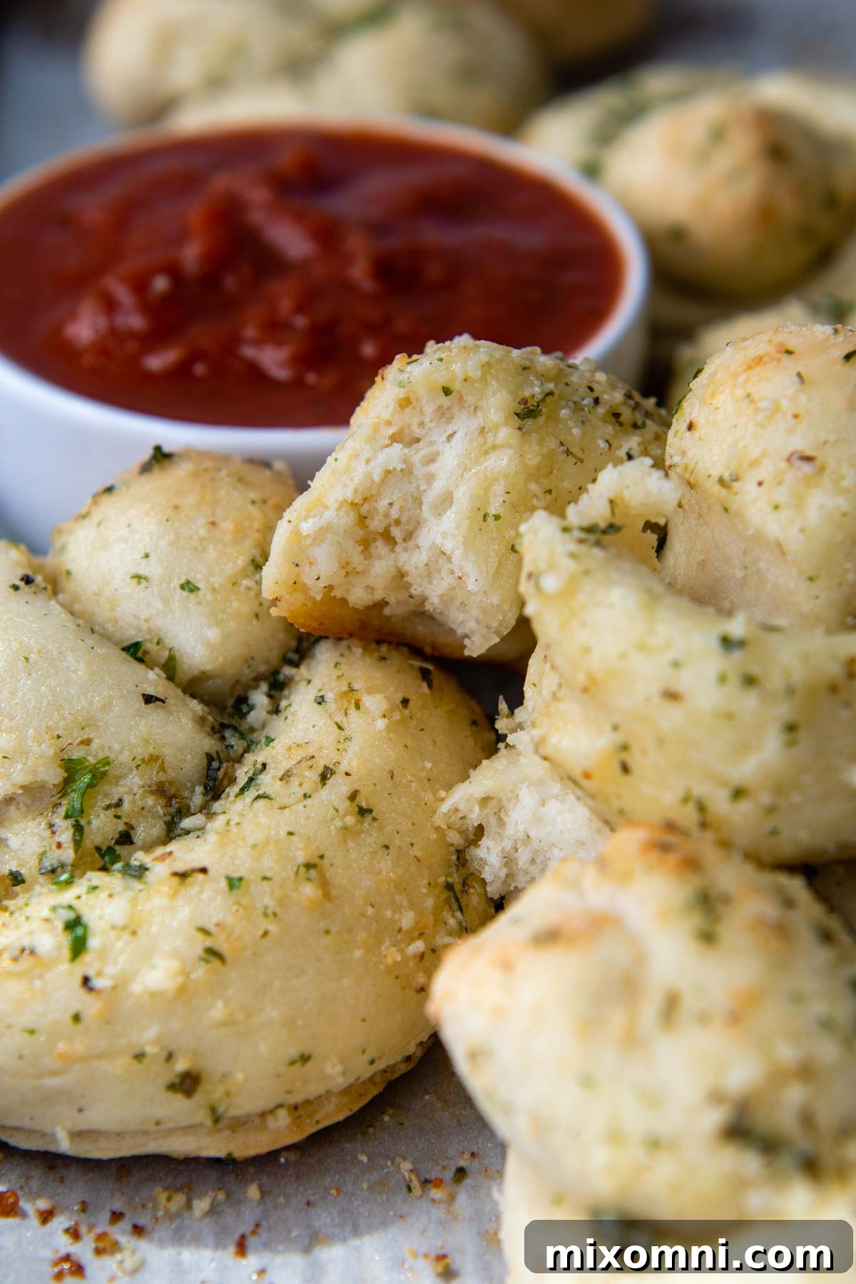A close-up image showcasing the soft, airy internal texture of a freshly baked gluten-free garlic knot, indicating a perfectly cooked and tender crumb.