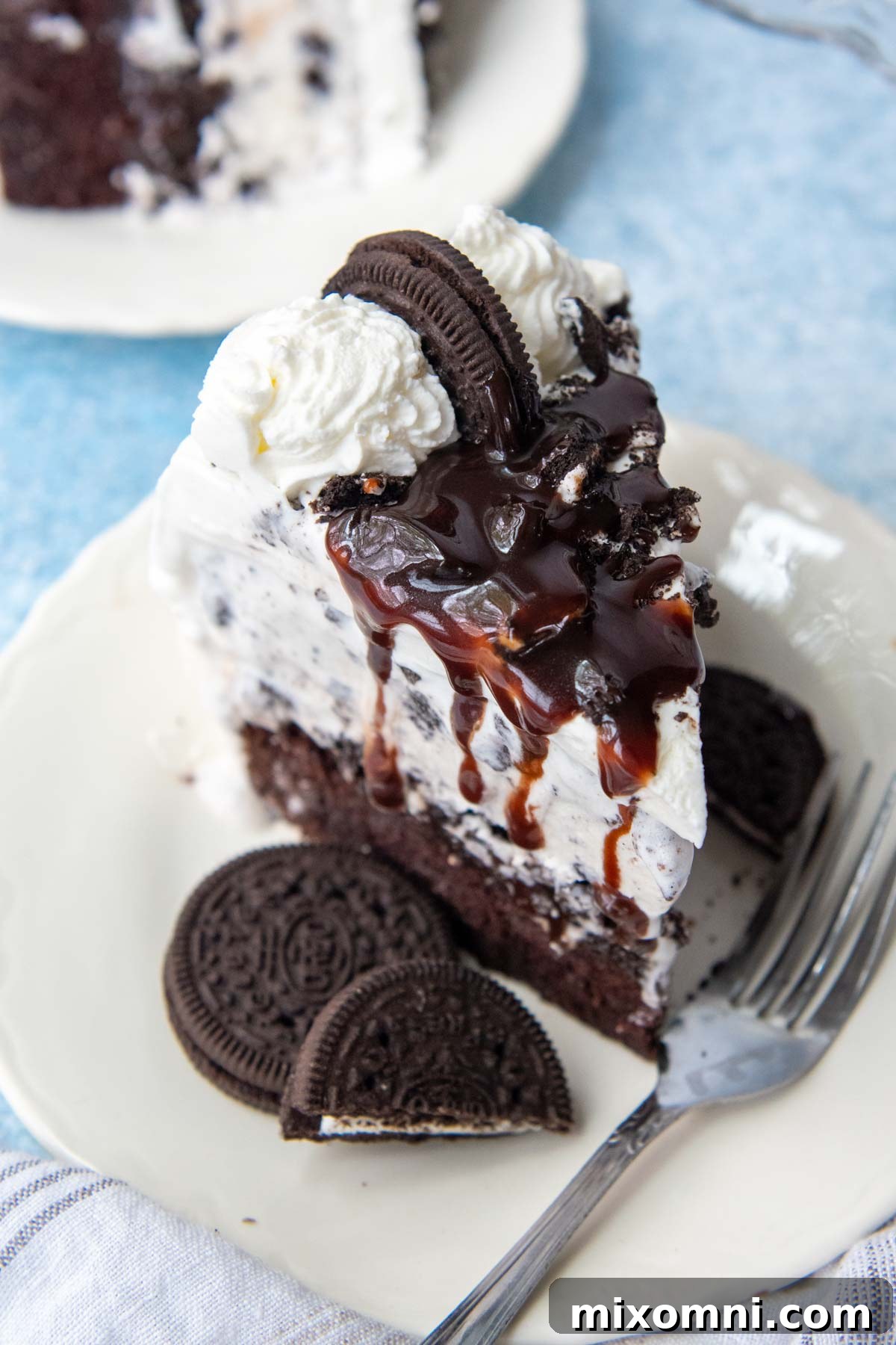 The top of a slice of homemade gluten-free ice cream cake with a generous drizzle of hot fudge.