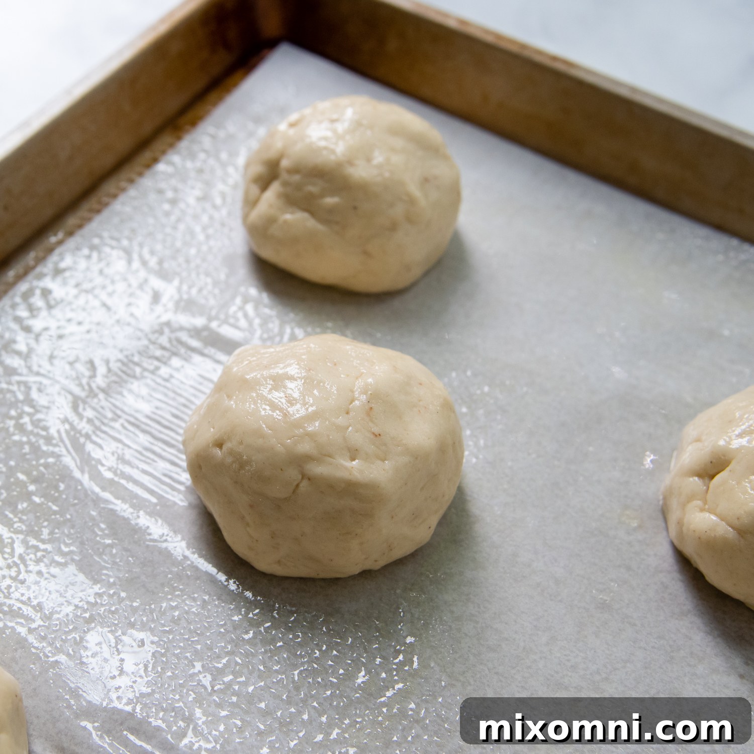 shaped buns before rising on a baking sheet.