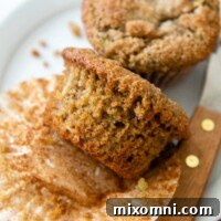 An almond flour zucchini muffin with the paper wrapping taken off, ready to eat.