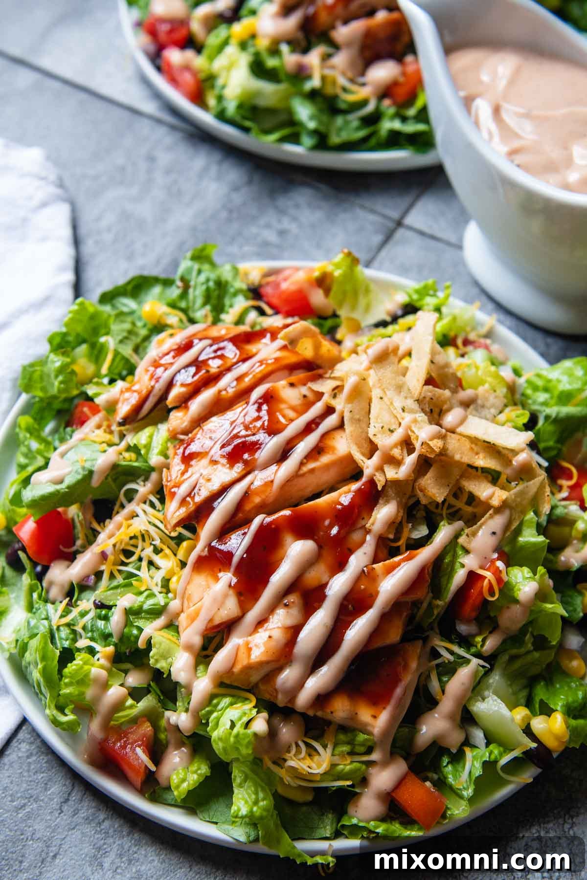 a salad with bbq ranch dressing drizzled on top.