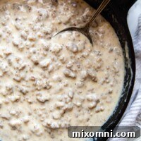 overhead shot of sausage gravy in a cast iron skillet.