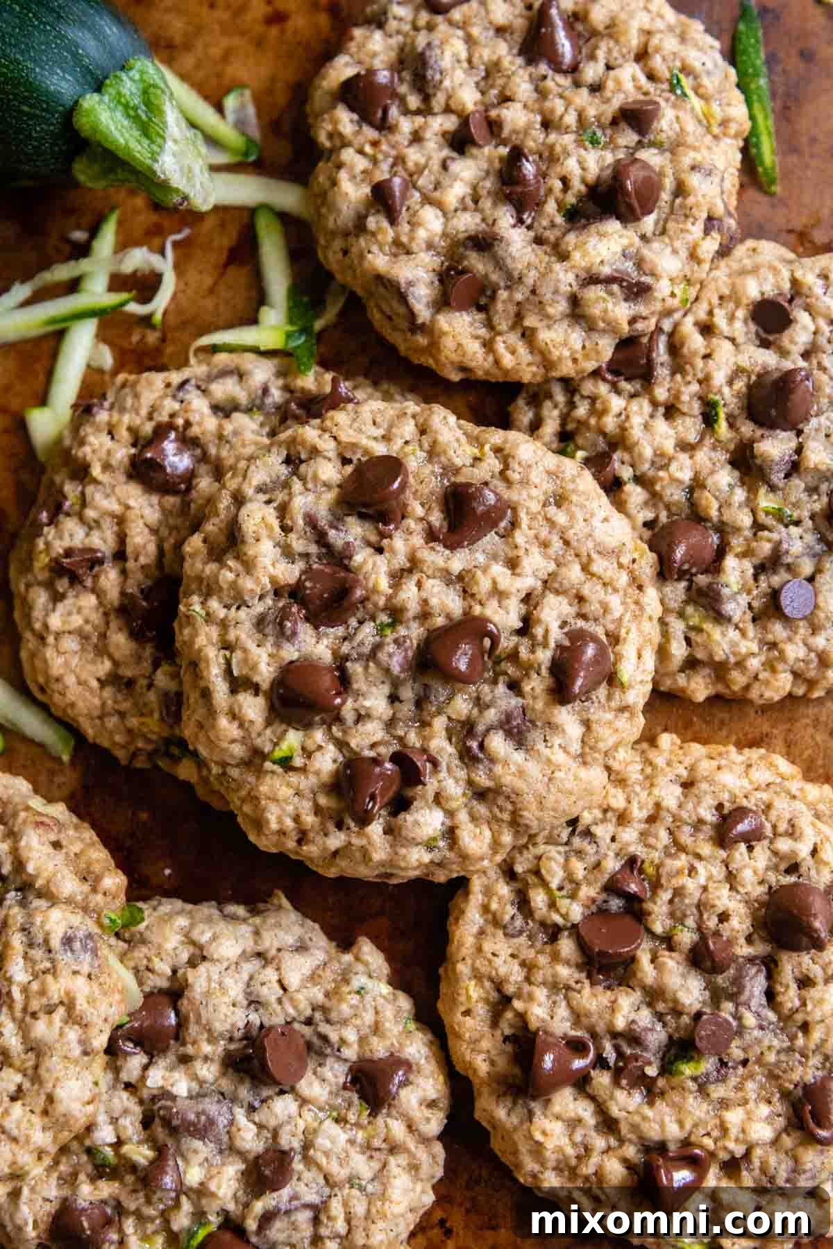 Overhead shot of freshly baked gluten-free zucchini cookies, adorned with melty chocolate chips, arranged artfully on a cooling rack.