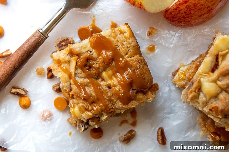 a sliced apple bar on waxed paper with caramel sauce drizzled over it
