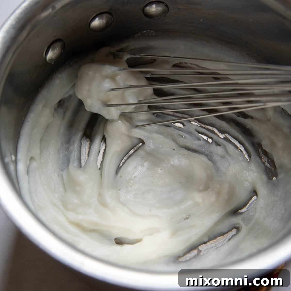 Preparing the tangzhong roux in a small saucepan, a key step for soft gluten-free rolls.