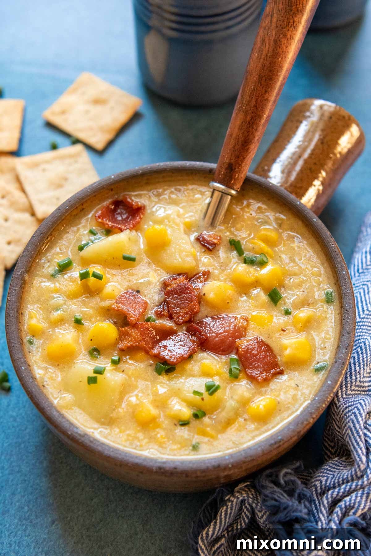 A close-up shot of a steaming bowl of gluten-free corn chowder, showcasing its rich, creamy texture and vibrant ingredients, ready to be enjoyed.