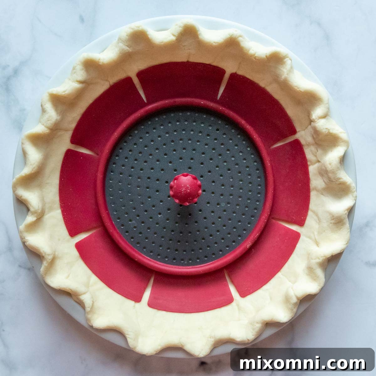 A ceramic pie weight nestled inside an unbaked gluten-free pie crust, ready for pre-baking to ensure a flaky foundation.