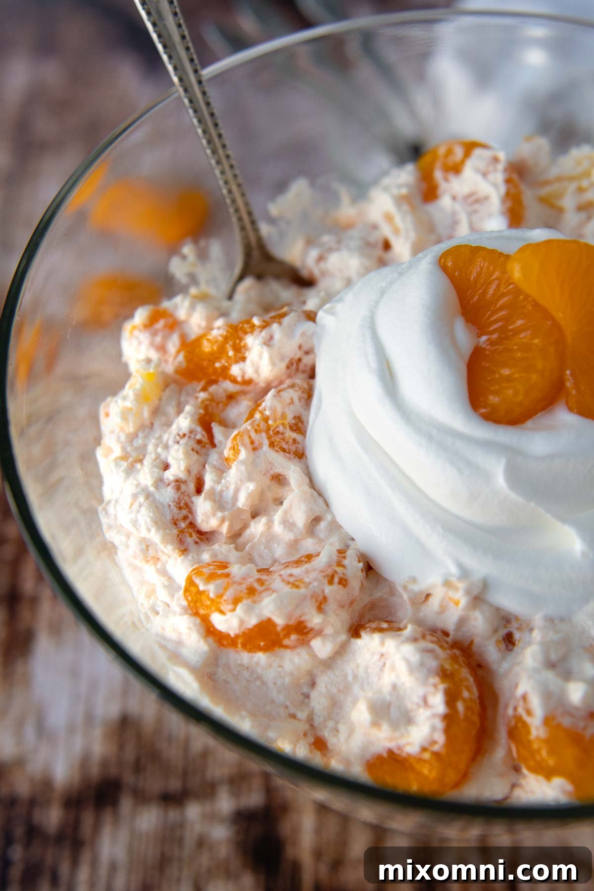 close up of the top of orange fluff with whipped cream on top.