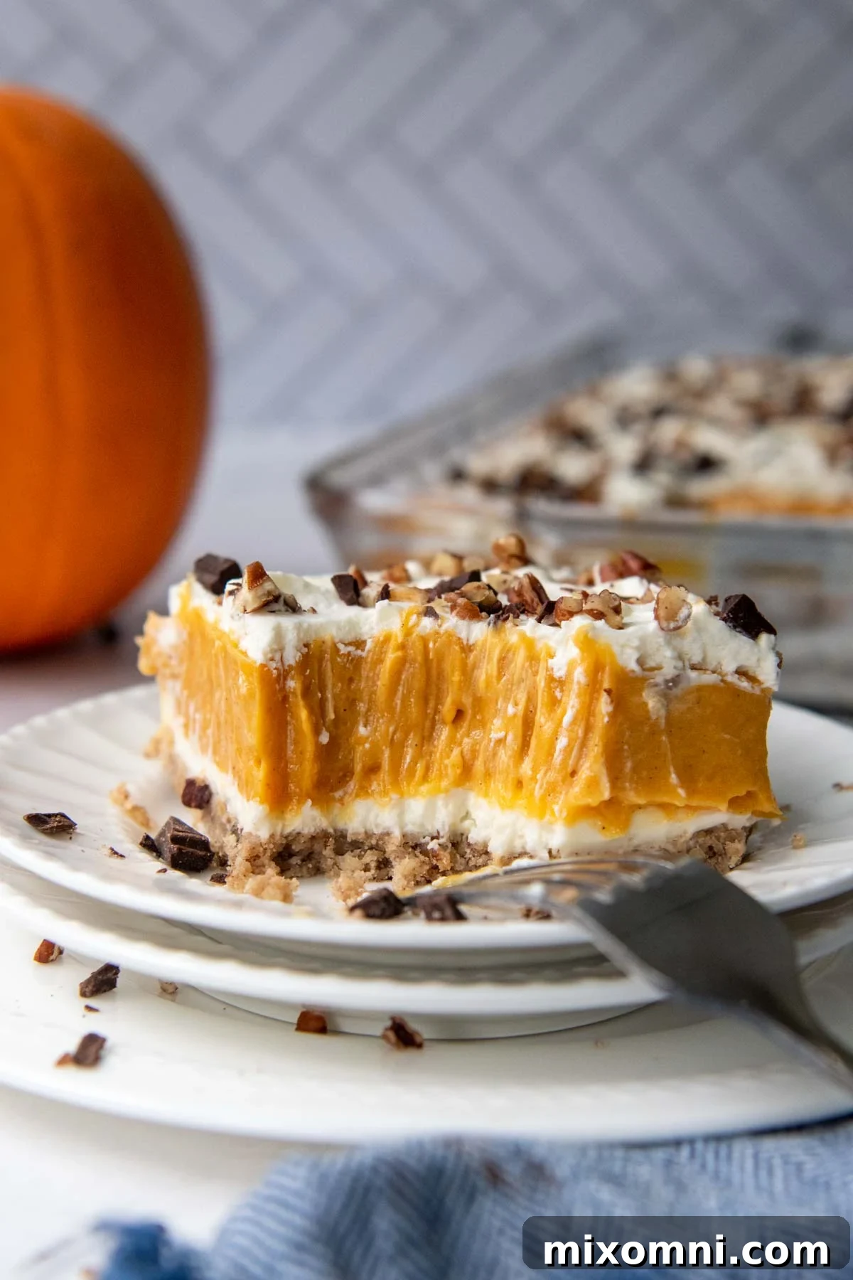 a bite taken out of dessert with a pumpkin in the background