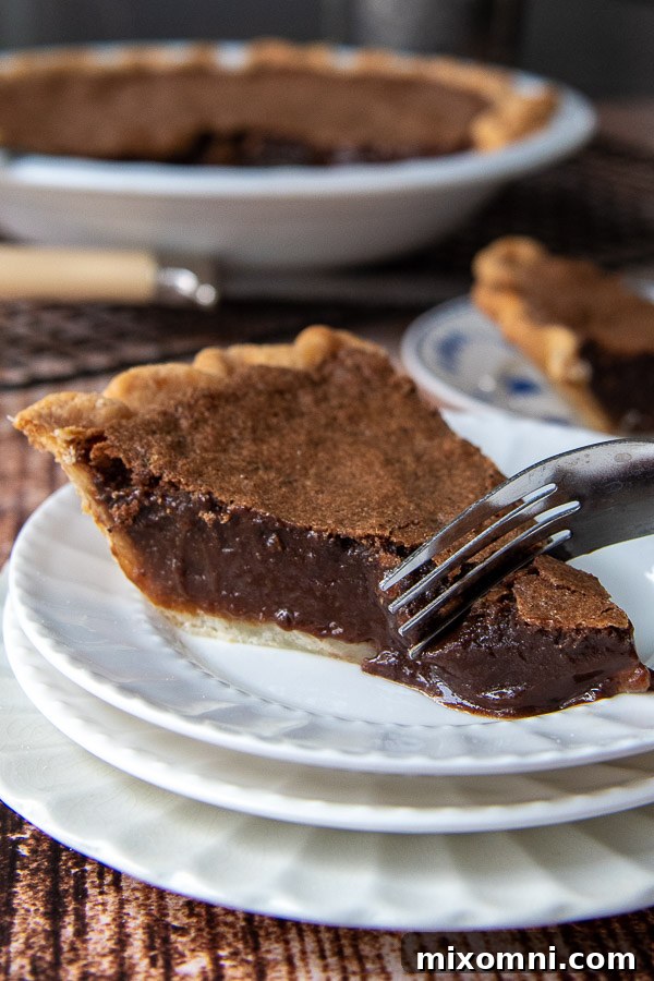 a fork cutting into a piece of chocolate chess pie
