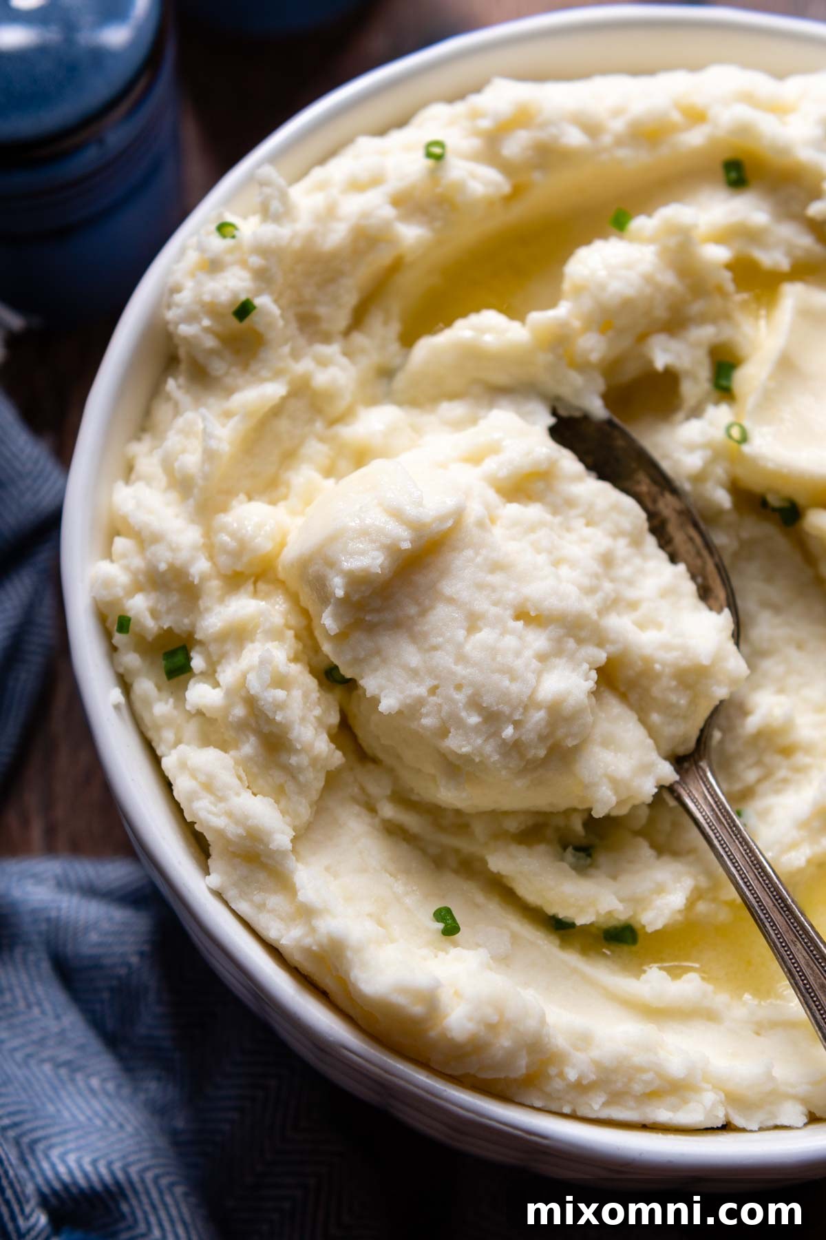 a spoon going into a bowl of potatoes