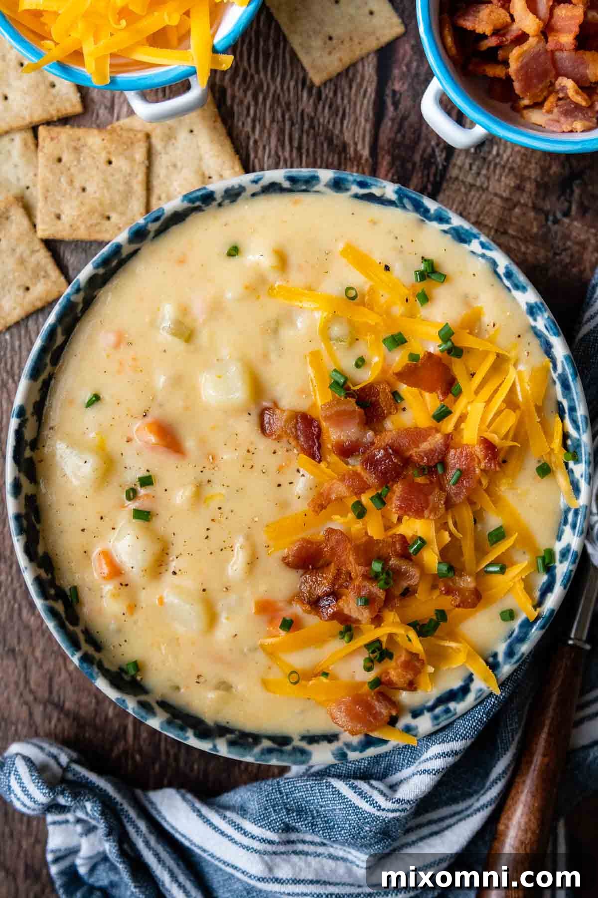 An inviting overhead shot of a bowl of gluten-free potato soup, surrounded by an assortment of fresh, colorful fixings and garnishes ready for customization.