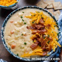 a bowl of potato soup on a wood background in a blue bowl.