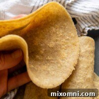 An almond flour tortilla being held up to show how flexible it is.