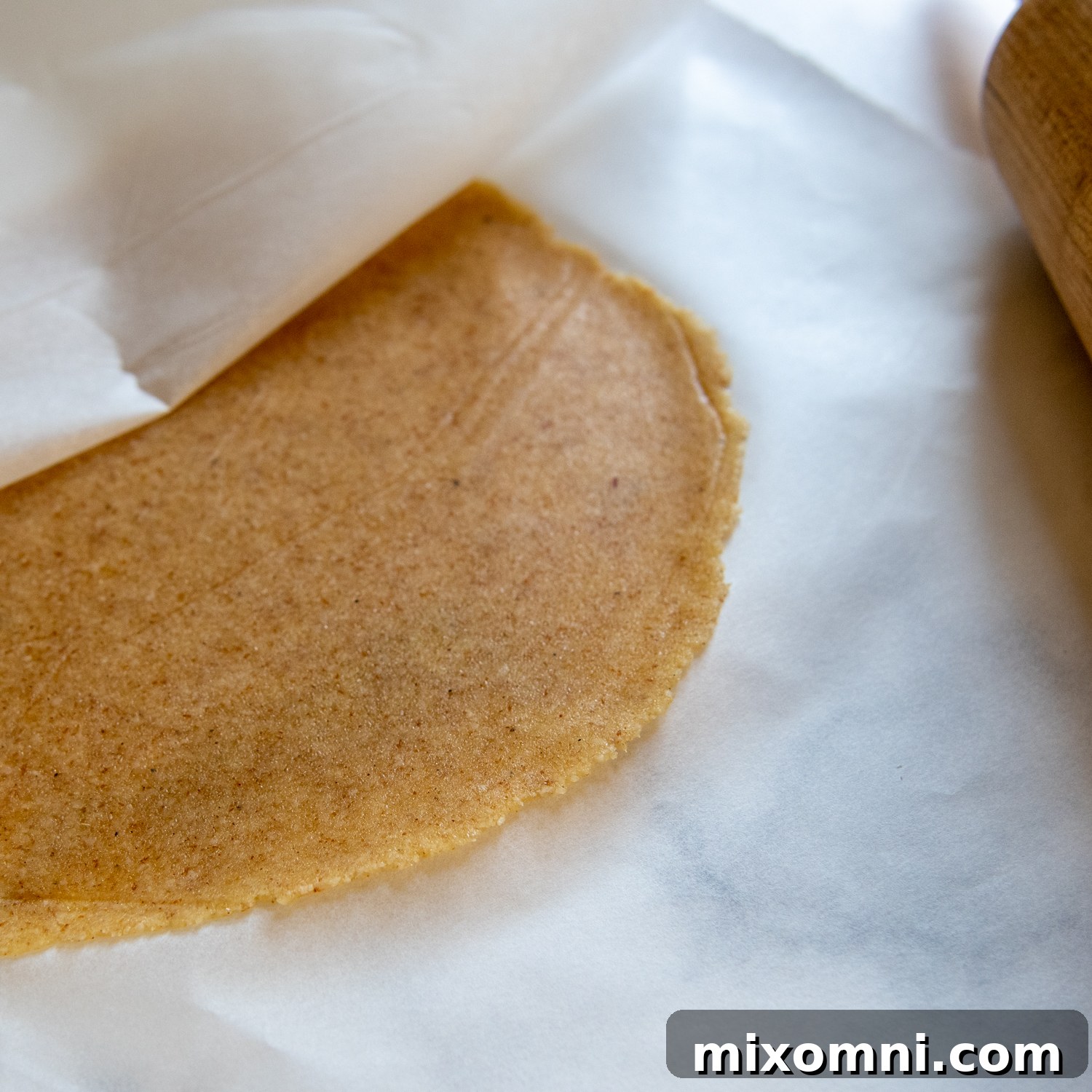 Showing the thinness of the almond tortilla after being rolled out.
