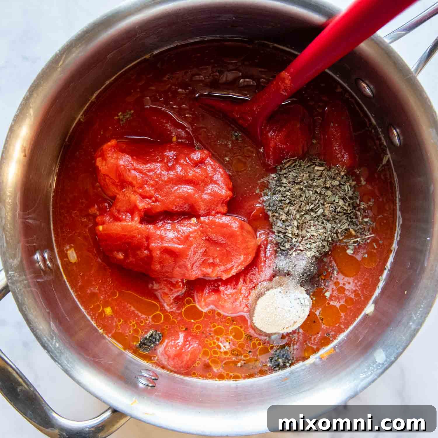 Whole canned tomatoes added to the pot with other ingredients, simmering.