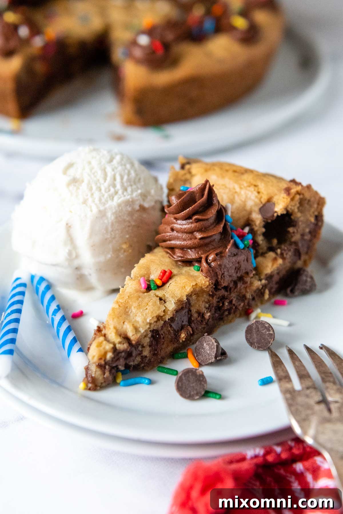A delicious slice of gluten-free cookie cake artfully plated next to a generous scoop of vanilla ice cream, ready to be enjoyed.